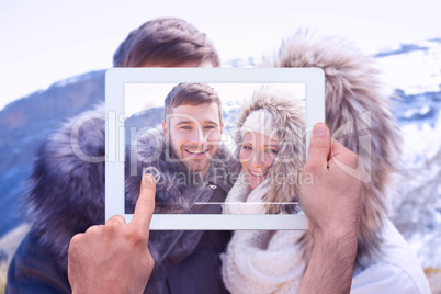 Composite image of hand holding tablet pc