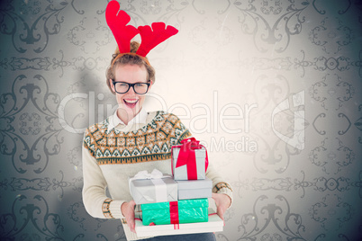 Composite image of happy geeky hipster holding presents