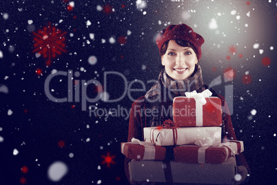 Composite image of smiling woman holding large presents