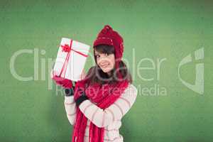 Composite image of smiling brunette showing a gift