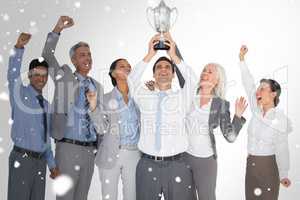Composite image of business people holding cup and cheering