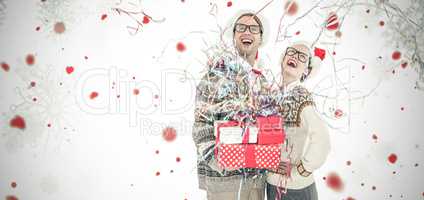 Composite image of happy man holding gifts and woman during christmas