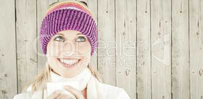 Composite image of smiling woman with a colorful hat and a cup i