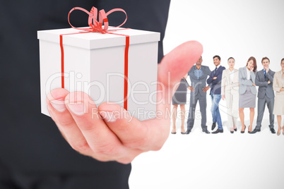 Composite image of businessman holding out his hand