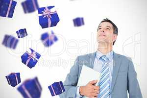 Composite image of excited cheering businessman holding his lapt