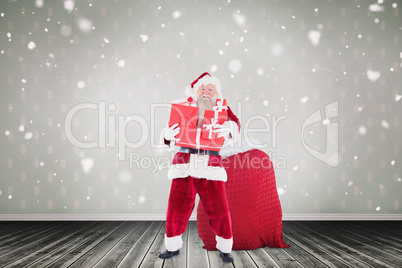 Composite image of santa holding pile of gifts