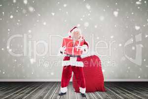 Composite image of santa holding pile of gifts