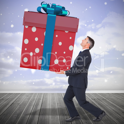 Composite image of stylish man with giant gift