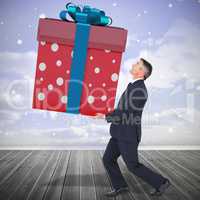 Composite image of stylish man with giant gift