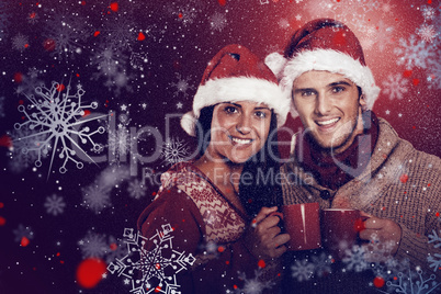 Composite image of young festive couple holding mugs