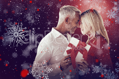 Composite image of loving couple with gift