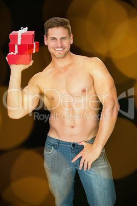 Composite image of muscular man holding pile of presents in blue