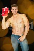 Composite image of muscular man holding pile of presents in blue