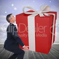 Composite image of stylish man with giant gift