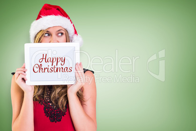 Composite image of festive blonde showing a tablet