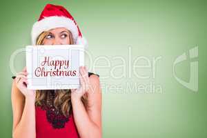 Composite image of festive blonde showing a tablet