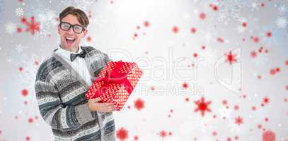 Composite image of happy geeky hipster with wool jacket holding present
