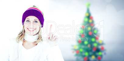 Composite image of joyful woman with a colorful hat pointing upw