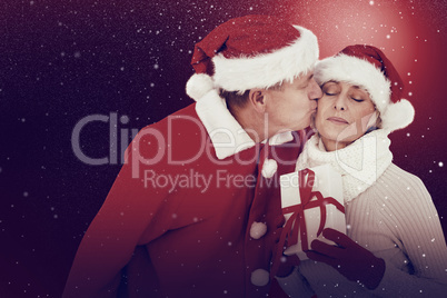 Composite image of festive mature couple holding gift