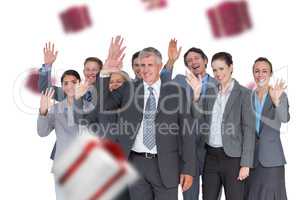 Composite image of smiling business team waving at camera