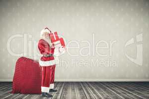 Composite image of santa claus carrying pile of gifts