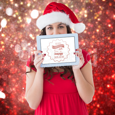 Composite image of festive brunette showing a tablet