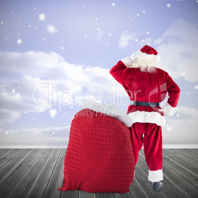 Composite image of santa with sack of gifts