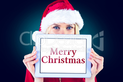 Composite image of festive blonde holding a tablet pc