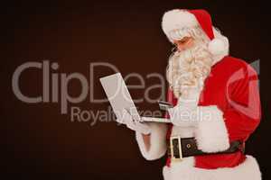 Composite image of santa claus shopping online with laptop