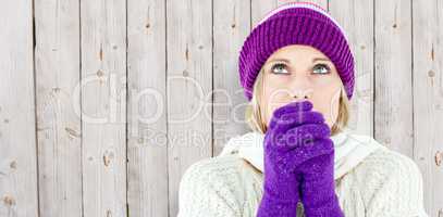 Composite image of freezing young woman wearing gloves looking u