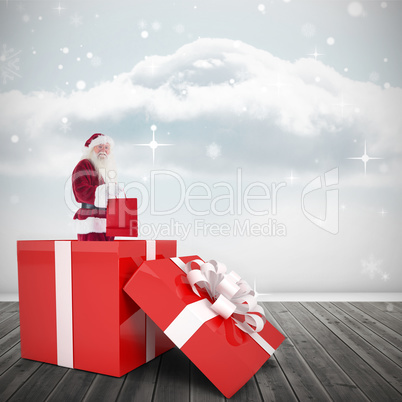 Composite image of santa standing in large gift