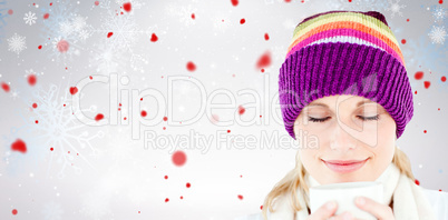 Composite image of delighted woman with a colorful hat and a cup