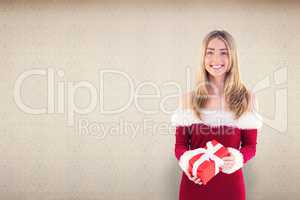 Composite image of pretty santa girl holding gift