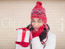 Composite image of content brunette in winter clothes holding gi