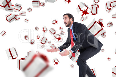 Composite image of bending businessman holding hand out while lo
