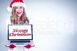 Composite image of festive blonde showing a laptop