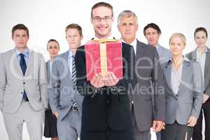 Composite image of smiling businessman holding out his hands