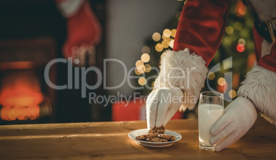 Santa claus picking cookie and glass of milk