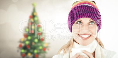 Composite image of smiling woman with a colorful hat and a cup i