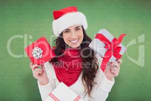 Composite image of happy brunette holding christmas gifts