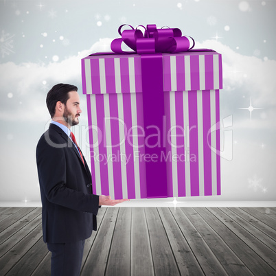 Composite image of stylish man with giant gift