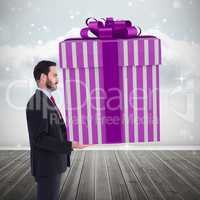 Composite image of stylish man with giant gift