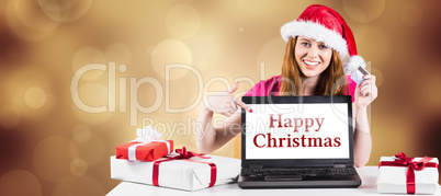 Composite image of festive redhead shopping online with laptop