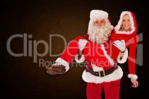 Composite image of santa and mrs claus smiling at camera