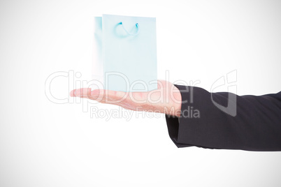 Composite image of businessman holding hand out in presentation