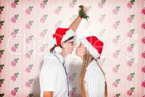 Composite image of geeky hipster kissing under mistletoe
