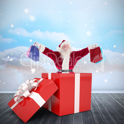 Composite image of santa standing in large gift