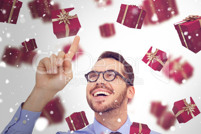 Composite image of happy businessman with glasses pointing