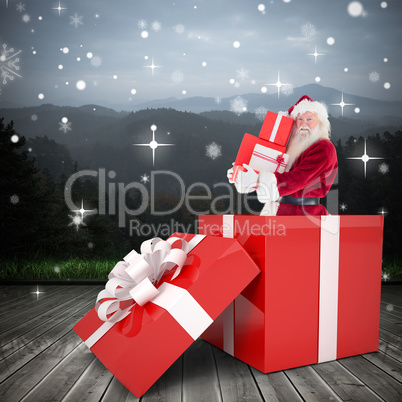 Composite image of santa standing in large gift