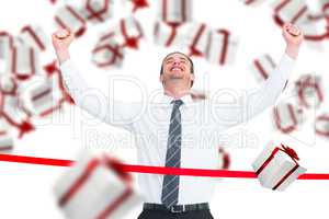 Composite image of happy businessman crossing the finish line